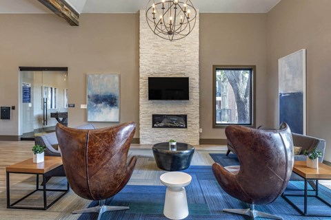 a living room with two leather chairs and a fireplace